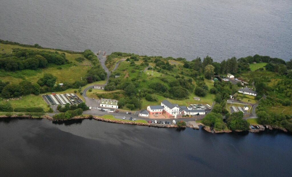 Aerial view of the Burrishoole research station, with buildings and monitoring facilities on a wooded strip of land between two bodies of water.